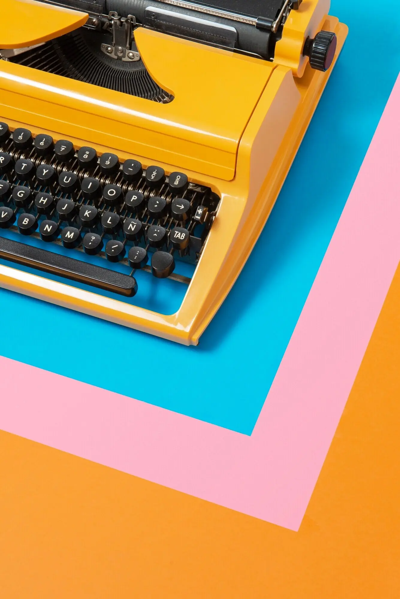 Leuchtend bunte Retro-Schreibmaschine mit Tastatur und Knöpfen.